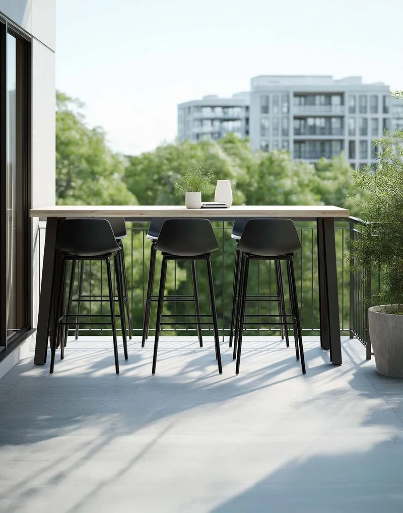 Hoher Bartisch aus hellem Holz mit schwarzem Metallgestell und sechs schwarzen Barhockern auf einem modernen Balkon mit Stadtblick.